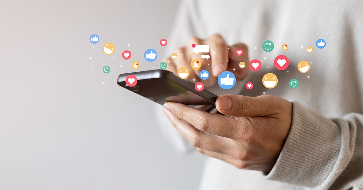 An adult man hand holds a smartphone and uses a social media network application.