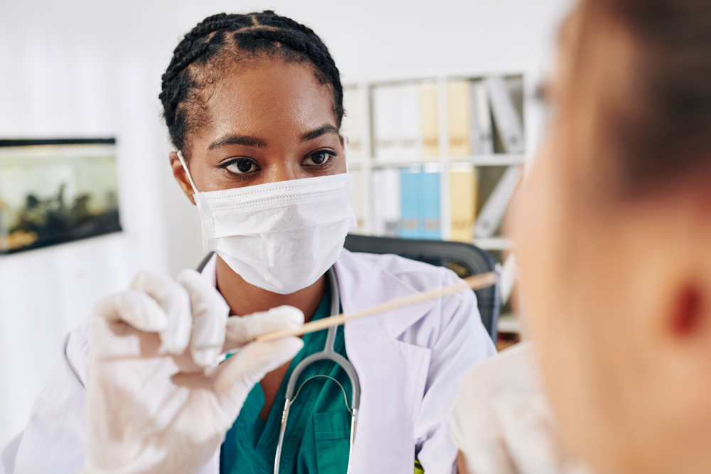 Doctor wearing a facemask with a patient