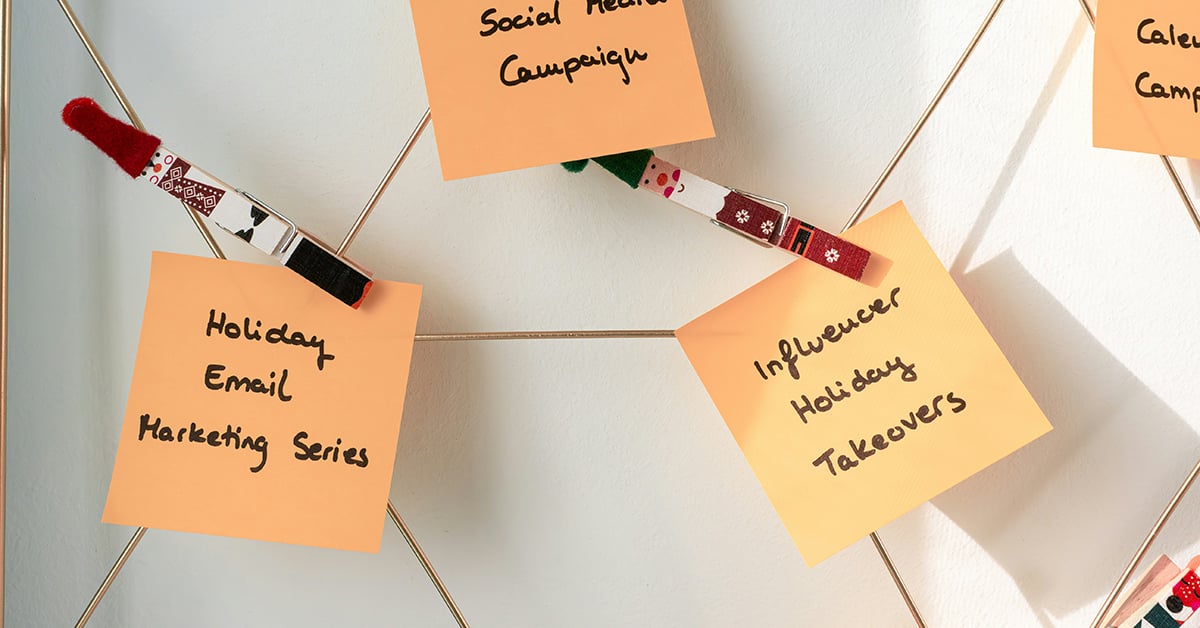 Post-it notes that say "Holiday email campaign," and "influencer holiday takeover" pinned to strings with nutcracker pins.