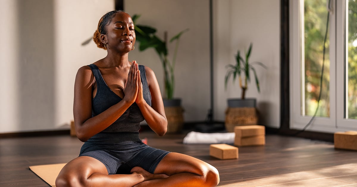 A woman in a relaxing yoga pose at her local yoga studio.