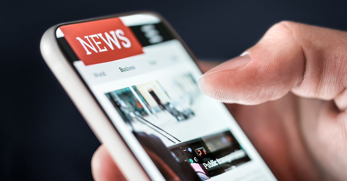 Reading latest headlines on digital mobile publication website or app with smartphone.