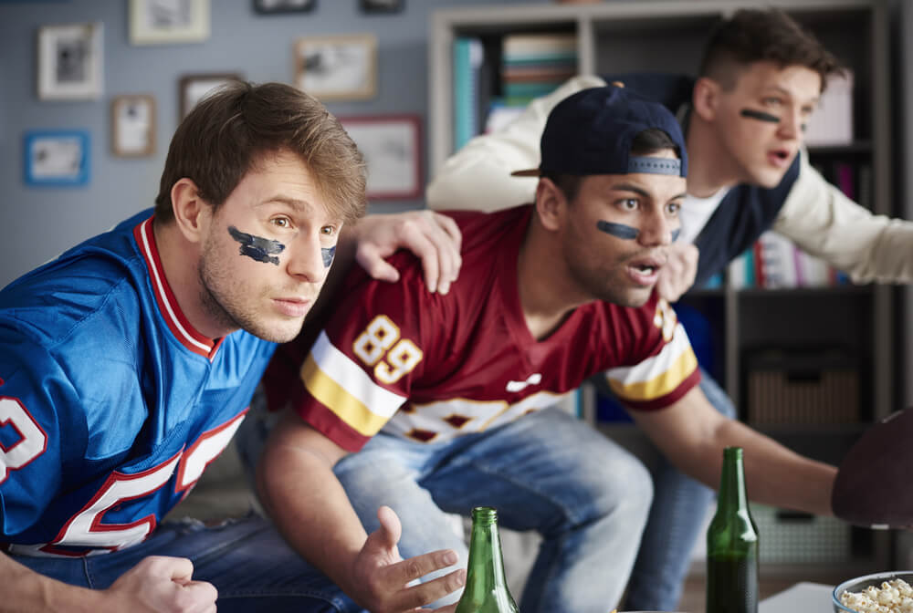 Group of fans watching sports game on TV