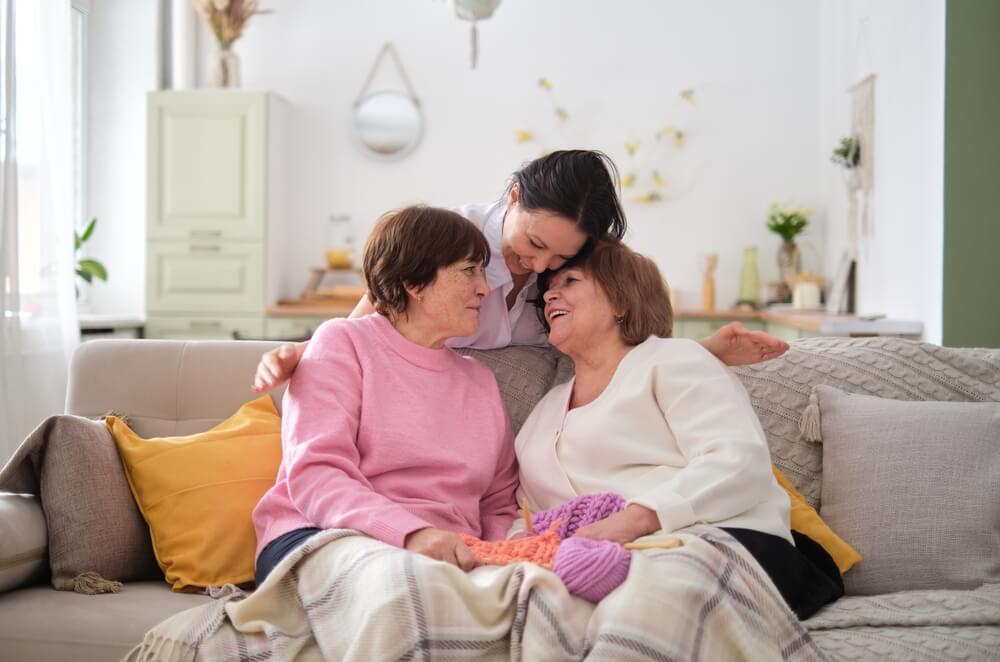 Adult children spending time with elder parent at senior living facility