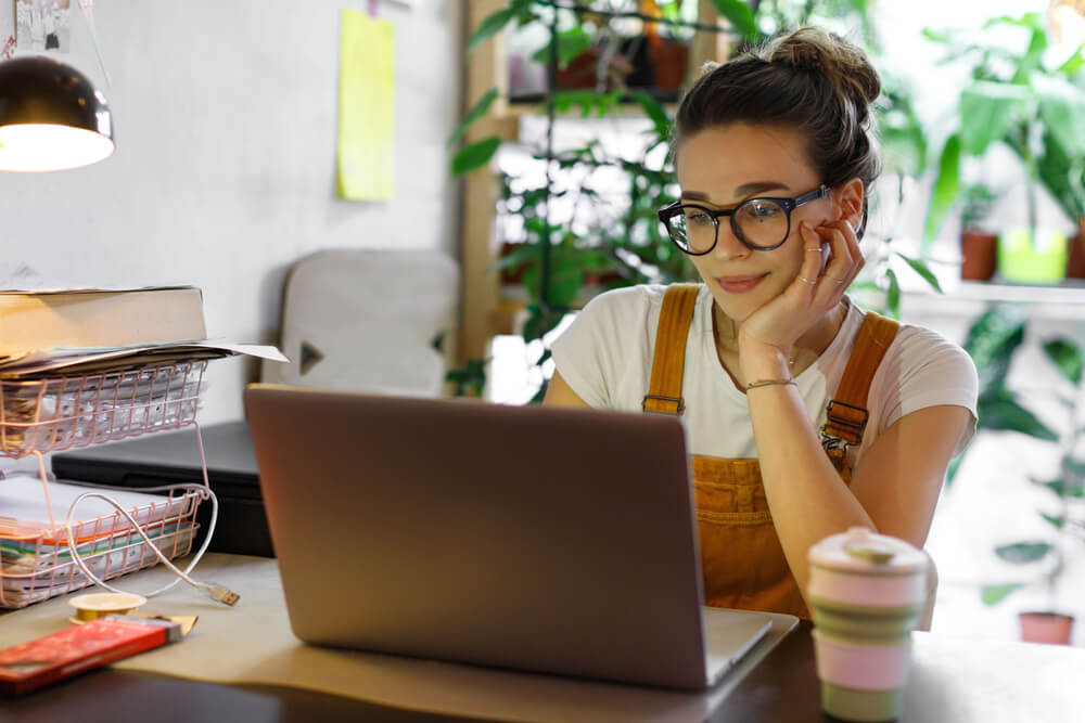 Woman browsing website, seeing personalized ads on home computer.