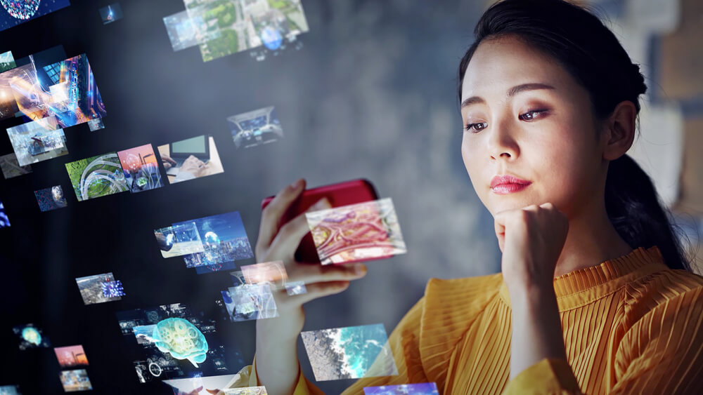 Woman watching YouTube videos on smartphone with video frames overlaid on image.